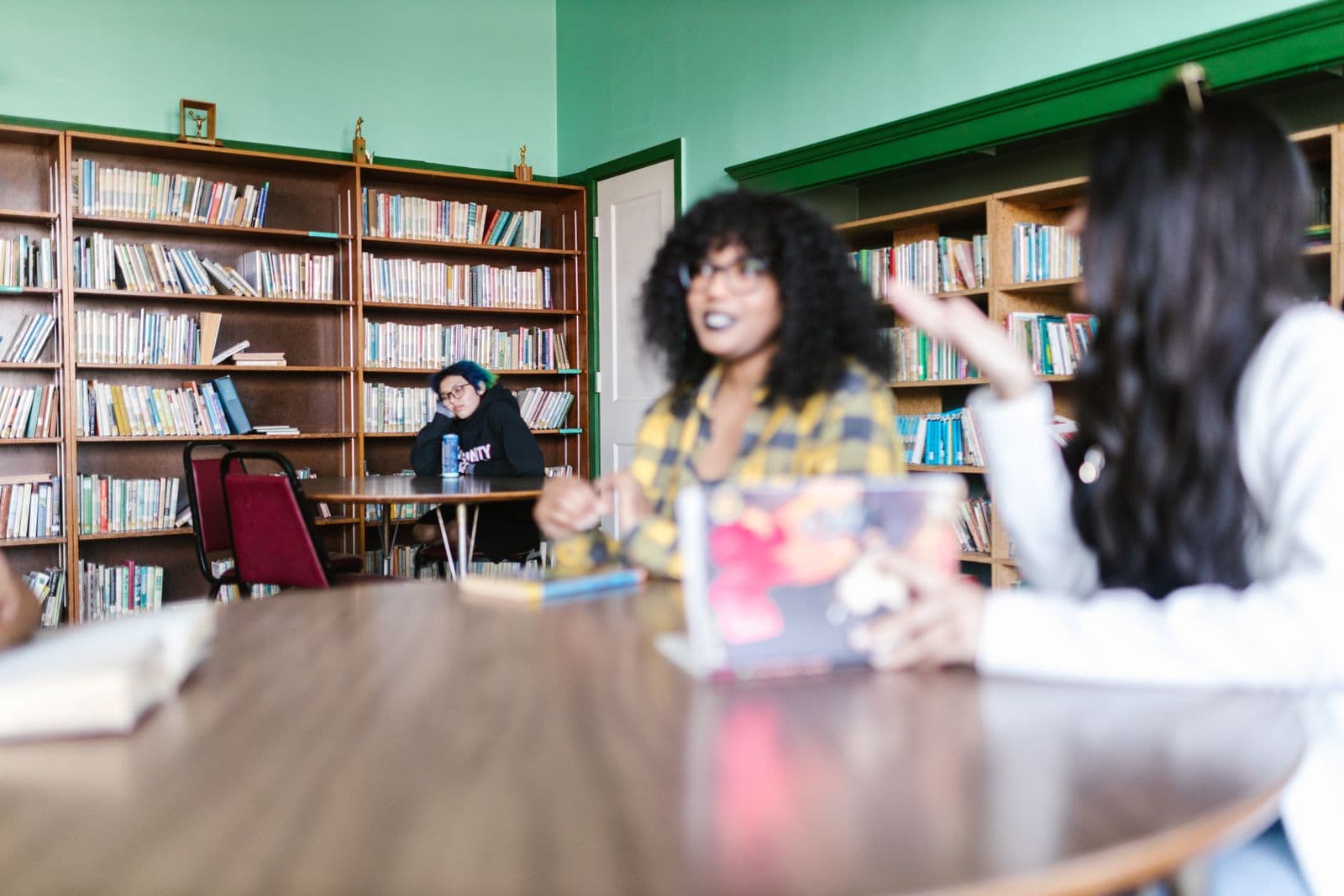 Two students in conversation at a library table