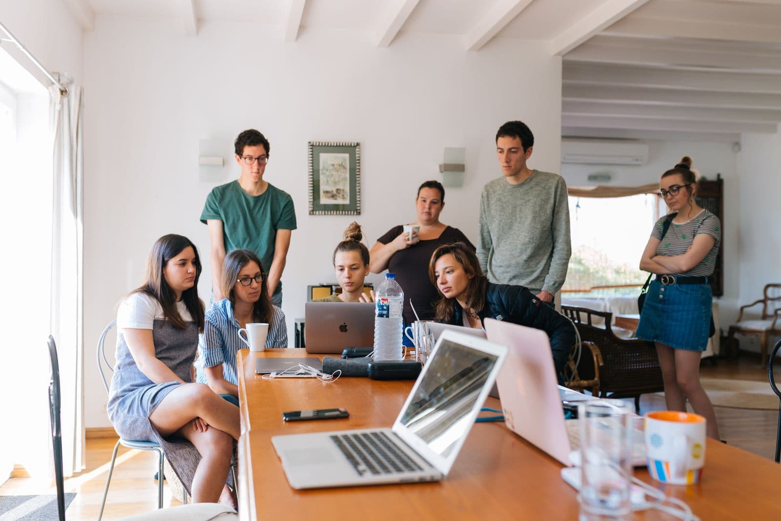 A team gathered around laptops reviewing a project
