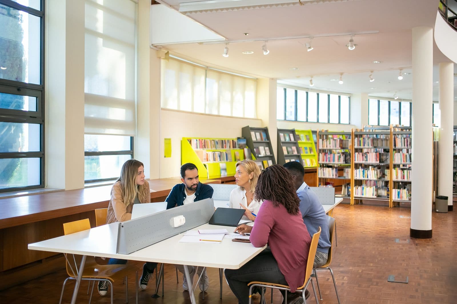 Postgraduate students discussing research in a library