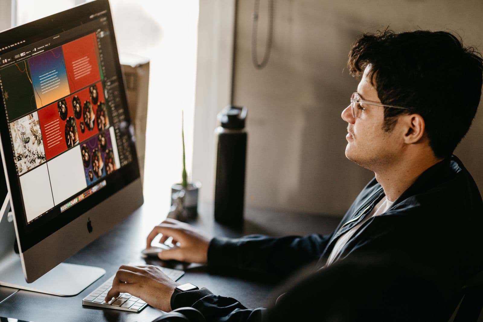A designer working on interface layouts on a large monitor