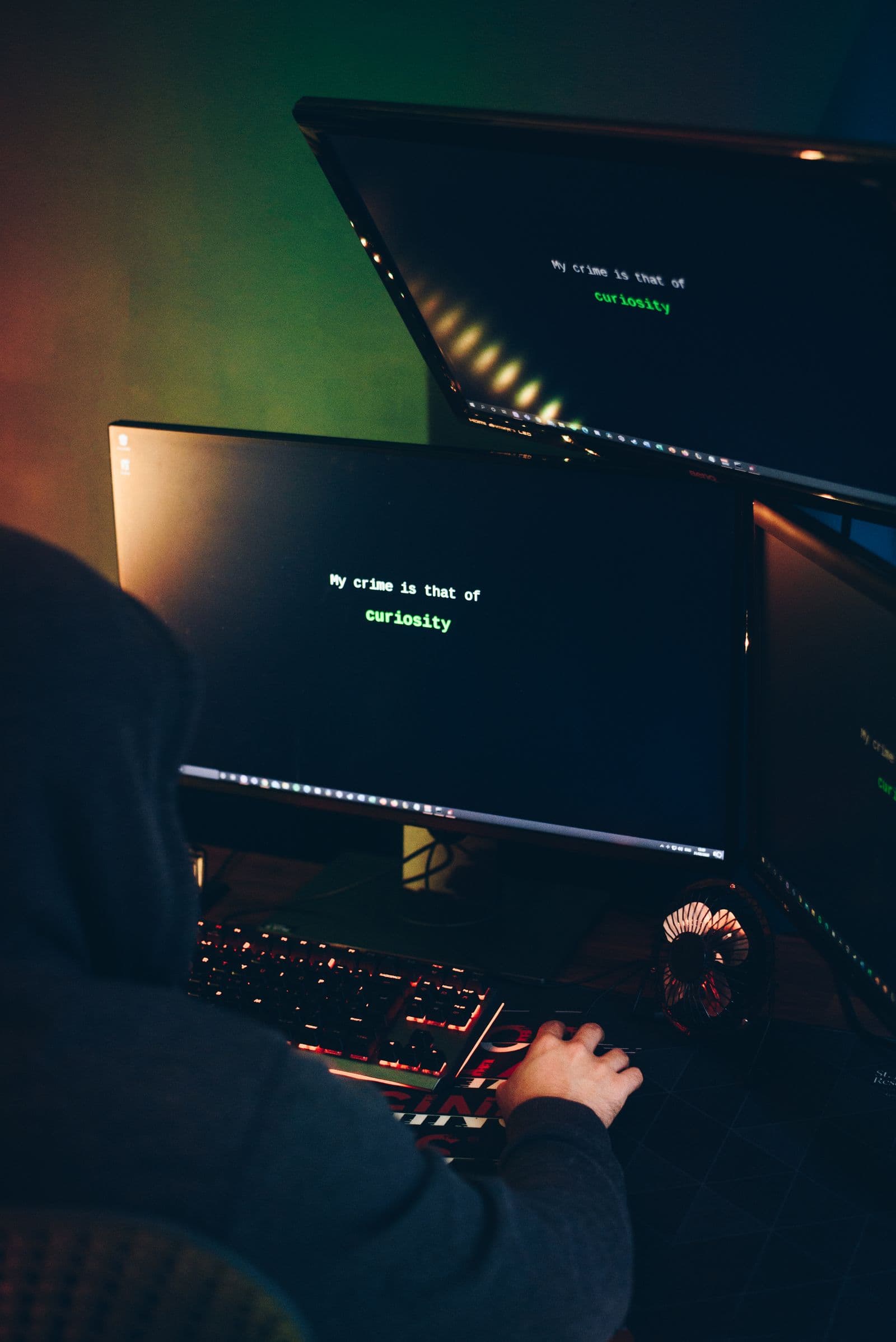 A person working at a laptop in a dimly lit room